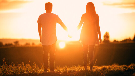 Young Couple Enjoying the Sunset Holding Hands photo