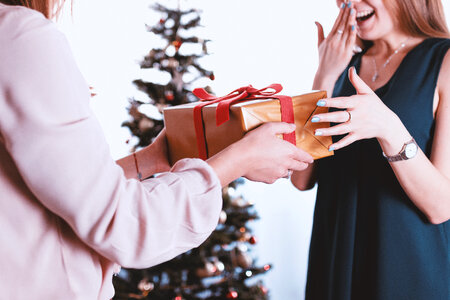 Happy and surprised woman receiving a gift. Merry Christmas photo