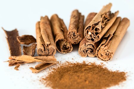 Cinnamon sticks with powder on white background photo