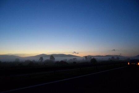 Foggy Hillside By Highway At Sundown photo