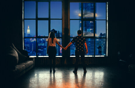 Couple Looking Out of Window in Luxary Apartment photo