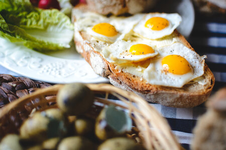 Fried quail eggs on bread with butter detail photo