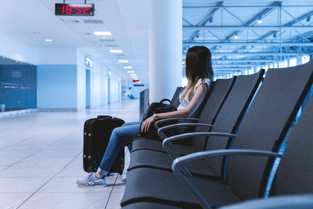 Young girl with long hair is sitting in airport. photo