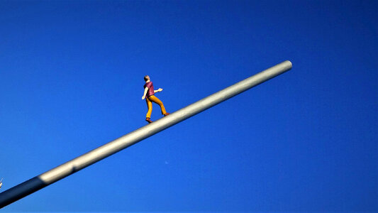 Man Figure walking towards sky on pole