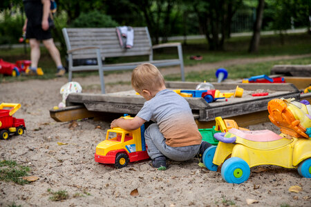Boy in a Sandbox Playing with a Truck photo