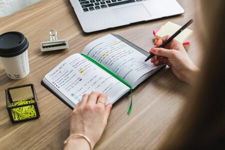 Writing In Notebook At Desk photo