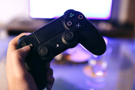 Detail gaming controller for the PlayStation console in the hand of player photo