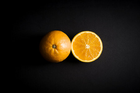 Orange Fruit Cut in Half on Black photo