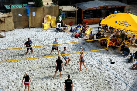 a group of young people playing volleyball on beach photo