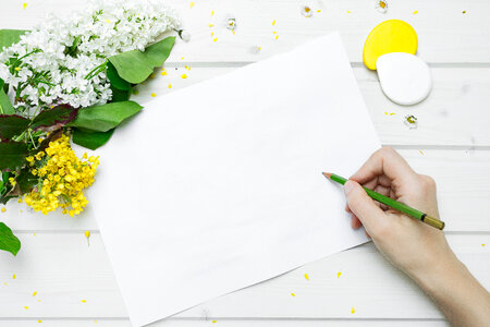 Blank Paper Card and Flowers on White Wooden Table photo