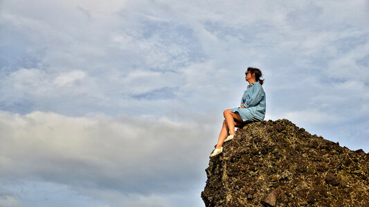 Girl sitting on a rock ledge photo