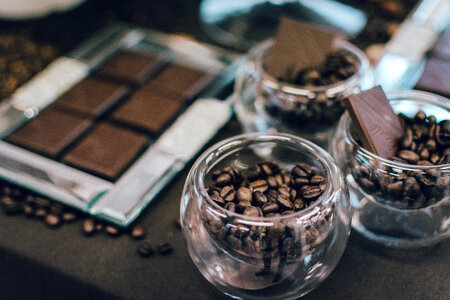 Dark chocolate bar and coffee beans in glasses photo