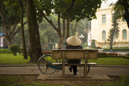 Person sitting on a bench on Hanoi, Vietnam photo