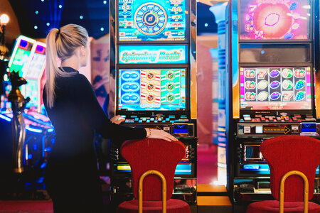 Woman is ready to play at slot machine in casino photo