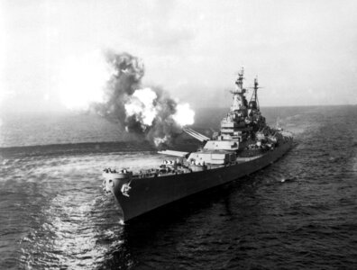 USS Missouri fires a salvo from its 16-inch guns at shore targets during Korean War