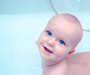 Lttle Baby Boy with Incredible Blue Eyes during the Bath photo