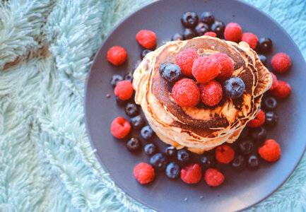 Pancakes with Blueberries and Raspberries on Black Plate photo