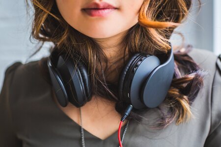 Woman wearing black over ear headphones around neck photo