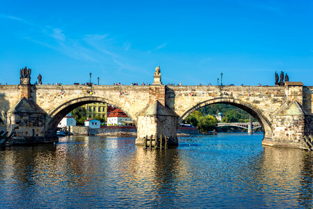 Charles Bridge over Vltava River against blue sky. Prague, Czech Republic photo