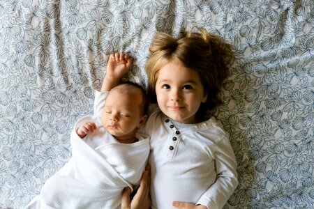 Cute big sister with new newborn baby photo