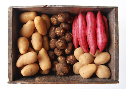 A variety of raw potatoes sweet potato and taro in wooden box photo