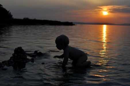 Kids play sunset sea