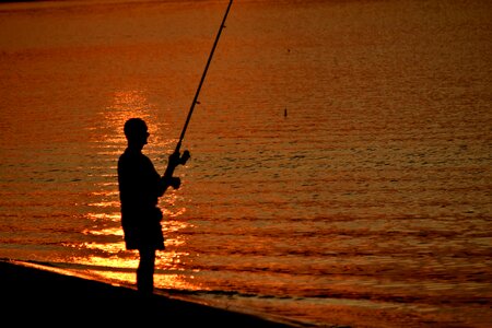 Beach sunset fisherman