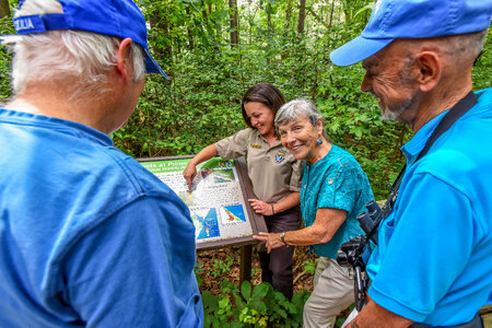FWS Visitor services staffer shows interpretive panel to visitors-3