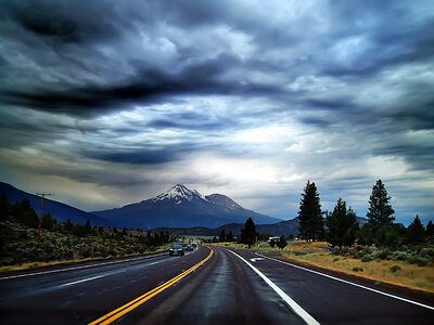 Highway Road into the mountains under heavy clouds photo