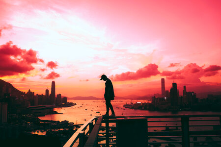 Man walking on the Railing, Victoria Harbor at Sunset, Hong Kong photo