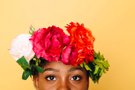 Woman with Flower Wreath on Her Head against Yellow Background photo