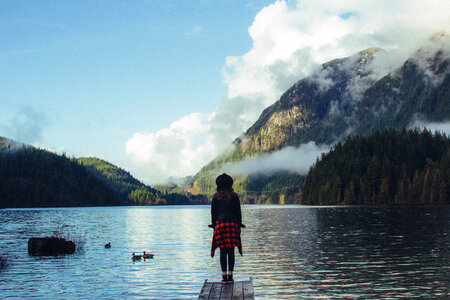 Young Woman Stands on a Wooden Pier, Buntzen Lake, Canada photo