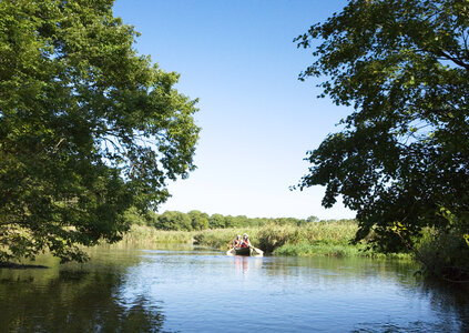 Woman paddling a boat carry tourist in the flooded forest