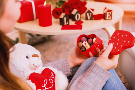 Happy and joyful young woman holding heart box with candies. Happy Valentine’s Day. photo