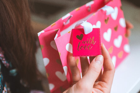 Valentine’s Day, Woman received a gift in a pink small bag from love photo