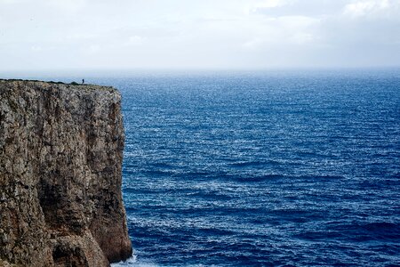 Solitary Person Standing at the Top of a Cliff
