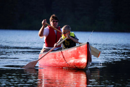 Man and boy paddle a canoe photo