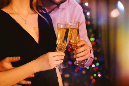 Man hugging his woman while they celebrate with champagne in hands at home