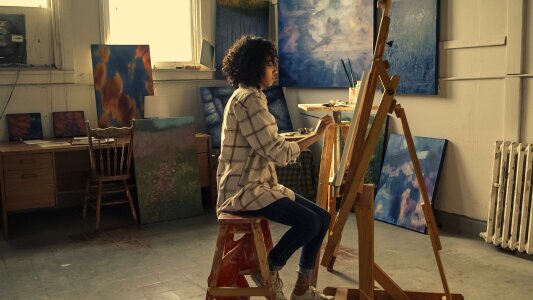 woman paints picture on canvas with oil paints in her studio photo