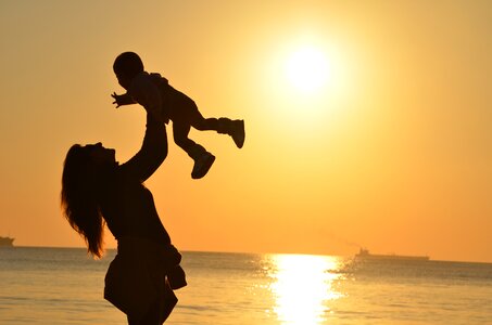 Mother with her Child on The Beach, Sunset photo