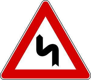 Double bend ahead sign in Italy