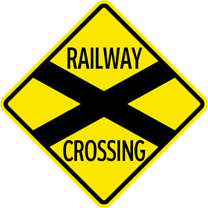 Level railroad crossing with barriers ahead sign in Jamaica