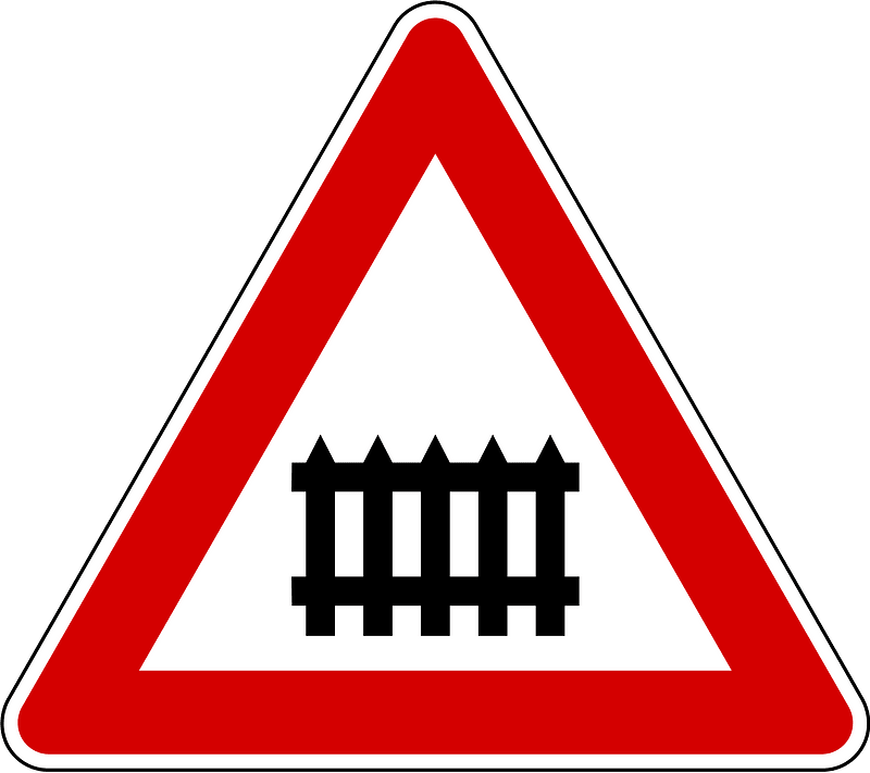 Level crossing with barriers ahead sign in Slovenia