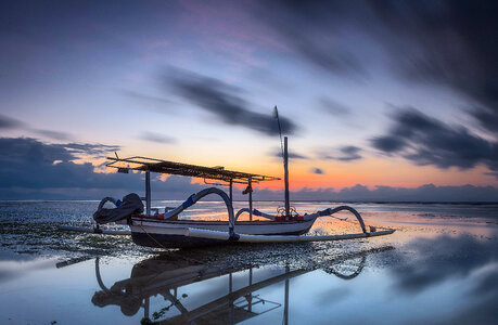 Boat under moving clouds on the water photo