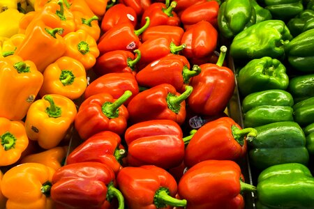 Red, orange and green peppers at a vegetable market all piled up