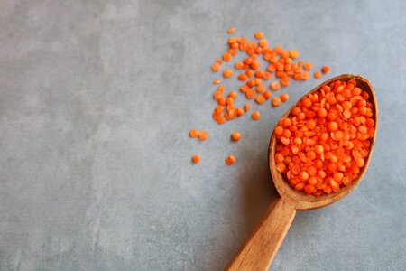 Red lentils in a wooden spoon photo