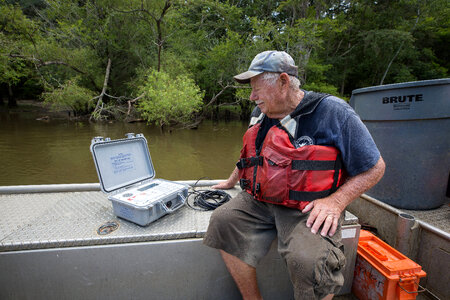 Biologist in boat study Gulf sturgeon in river