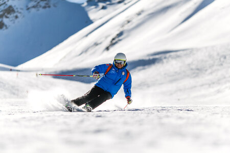 Man Skiing down a snowy mountain photo