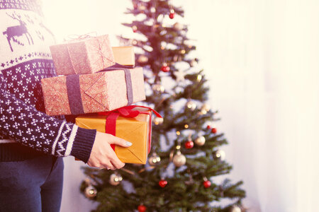 Woman’s hands hold christmas gift boxes. Merry Christmas photo