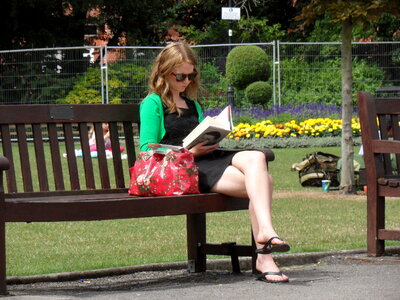 Beautiful woman sitting and reading book in park photo
